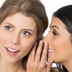 woman-speaking-into-ear-of-another-woman (1)